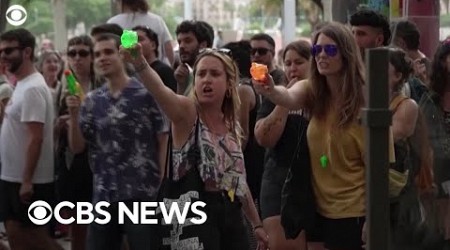 Mass tourism protesters in Barcelona, Spain, spray water at tourists